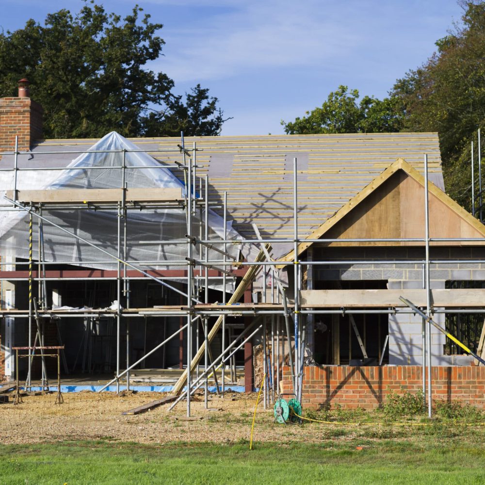 A family home under construction. A building site with scaffolding.