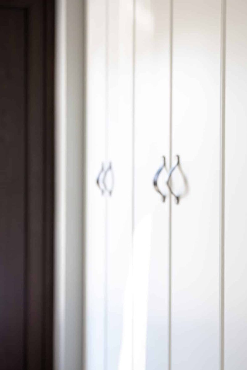 Interior of a modern residential home: detail of black kitchen drawer door handles.